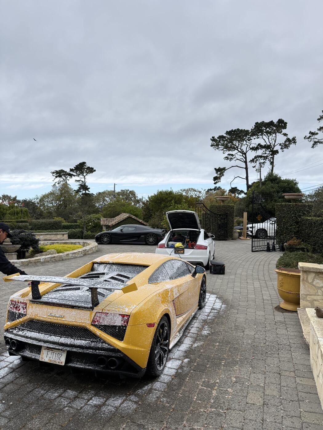 Two cars mid-wash on a client driveway